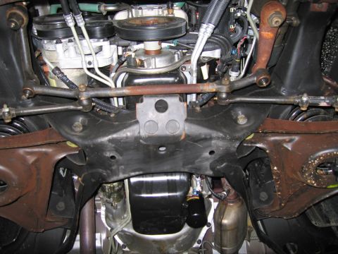 1991 Ford LTD Crown Victoria - Photograph of a vehicle undercarriage showing steering linkage and the front subframe, not a technical diagram.