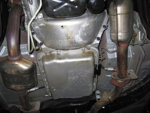 1991 Ford LTD Crown Victoria - Photograph of a vehicle underbody showing the oil pan and dual exhaust catalytic converters, not a technical document.
