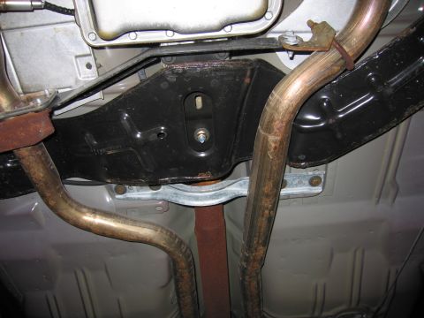 1991 Ford LTD Crown Victoria - Photograph of a vehicle undercarriage with dual exhaust pipes and a body crossmember, not a technical diagram.