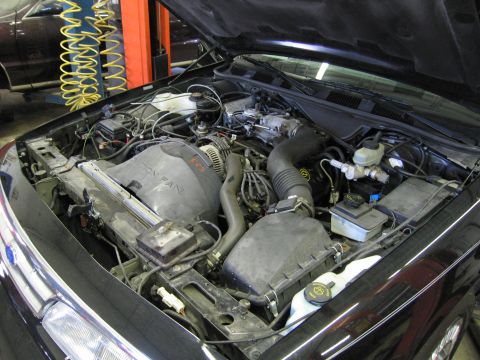 1991 Ford LTD Crown Victoria - Photograph of an open engine bay showing intake and master cylinder, not a technical document.