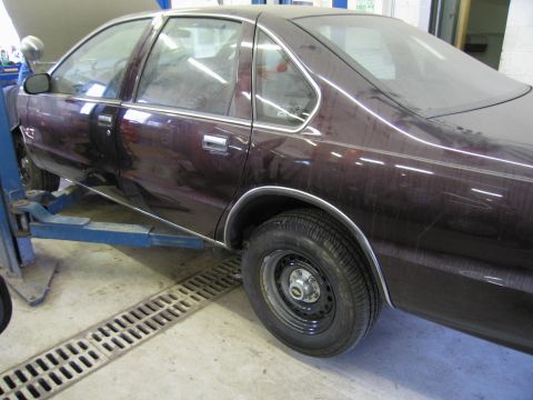 1991 Ford LTD Crown Victoria - Side view of a 1991 Ford Crown Victoria LTD being serviced on a lift.