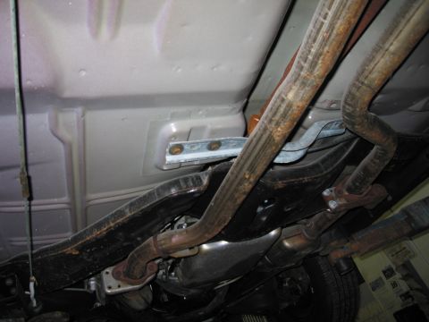1991 Ford LTD Crown Victoria - Close-up of the undercarriage, showing the exhaust pipes and structural elements.