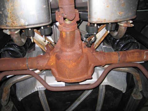 1991 Ford LTD Crown Victoria - The heavily rusted rear axle and exhaust components are visible from underneath the vehicle.