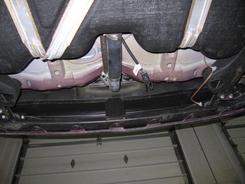1991 Ford LTD Crown Victoria - Underside view of a vehicle's fuel tank and exhaust system, showing suspension components.