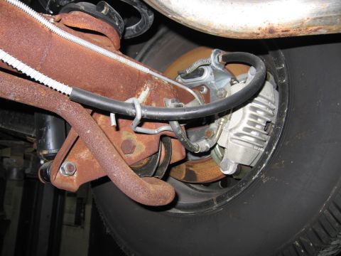 1991 Ford LTD Crown Victoria - Rear brake caliper and suspension components are heavily rusted.