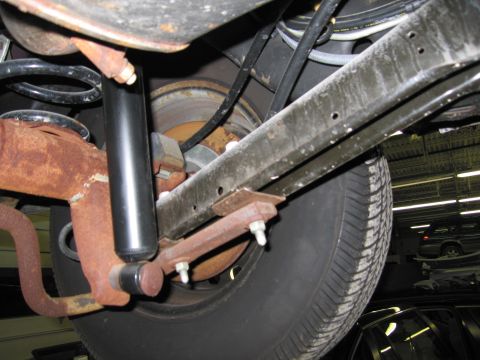 1991 Ford LTD Crown Victoria - Close-up view of a vehicle's rear suspension components and tire, showing rust and wear.