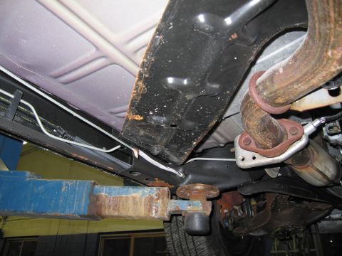 1991 Ford LTD Crown Victoria - Close-up of a vehicle's undercarriage, focusing on the exhaust system and frame.