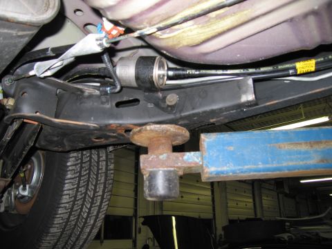 1991 Ford LTD Crown Victoria - Close-up view of a vehicle's undercarriage, focusing on the fuel filter and associated lines.