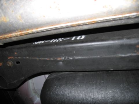 1991 Ford LTD Crown Victoria - Close-up of a vehicle's undercarriage part showing stamped markings.