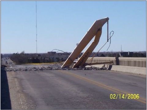 1995 Ford Bronco - A section of a bridge has collapsed, with heavy yellow demolition equipment resting on the roadway.