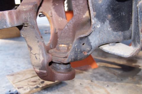 1990 Ford Bronco - This image shows a close-up of heavily rusted suspension components of a vehicle, likely a truck or SUV, with a ball joint assembly visible…