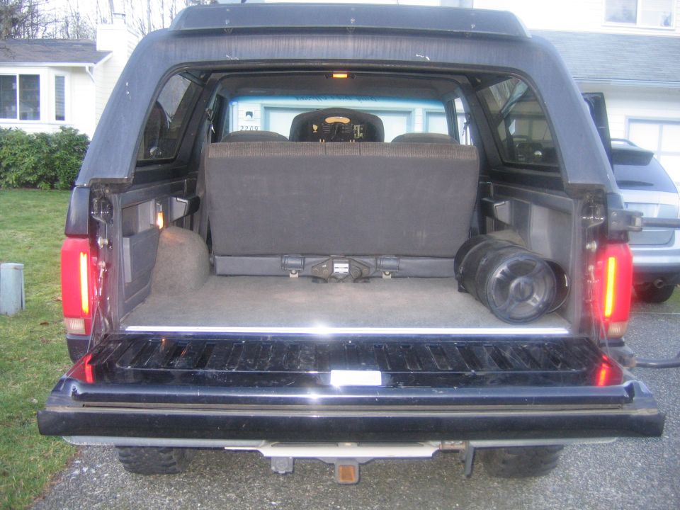 Open rear tailgate of a dark SUV showing cargo area