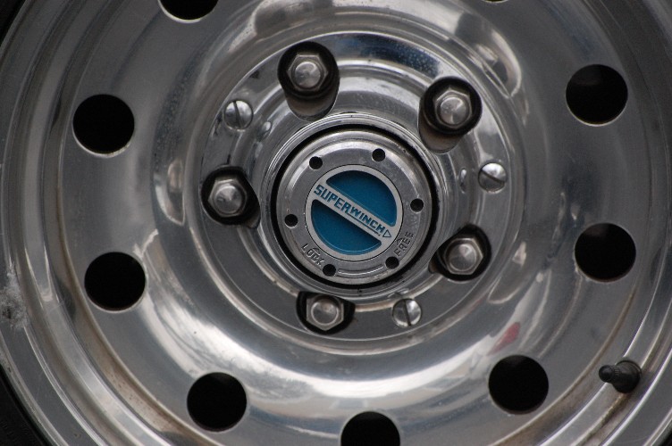 Chrome wheel hub with SuperWinch locking mechanism on a vehicle.