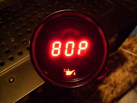 1972 Ford Ranchero - A red digital gauge displays "80P" with an oil can icon below it. The gauge is mounted on a dark, textured surface.