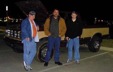 2007 Ford Mustang - Snapshot of people posing by a Ford pickup truck, not a technical document.