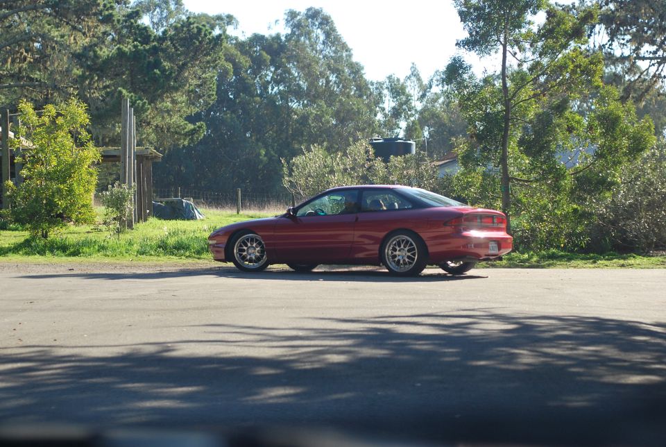 Red 1994 Ford Probe parked on the side of a road.
