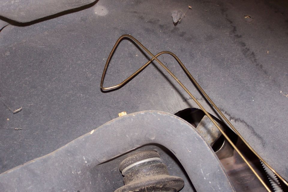 Bent metal line on underside of vehicle near suspension