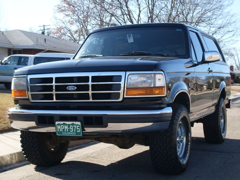 1996 Ford Bronco, black, front 3/4 view, chrome grille, aftermarket wheels, Colorado license plate