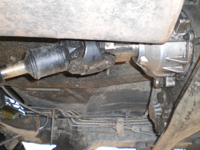 Underside view of a vehicle driveshaft and differential housing.