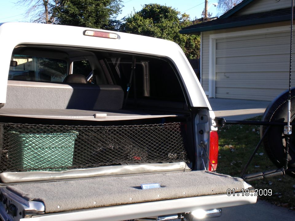 Open rear window and tailgate of white pickup truck cab
