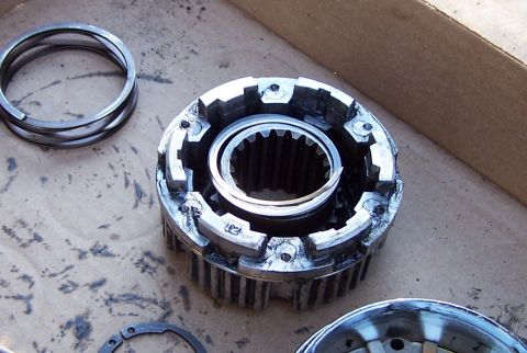 1990 Ford Bronco - A close-up shot shows a disassembled transfer case part with internal gears and a spring. A set of three metal rings are also visible to th…