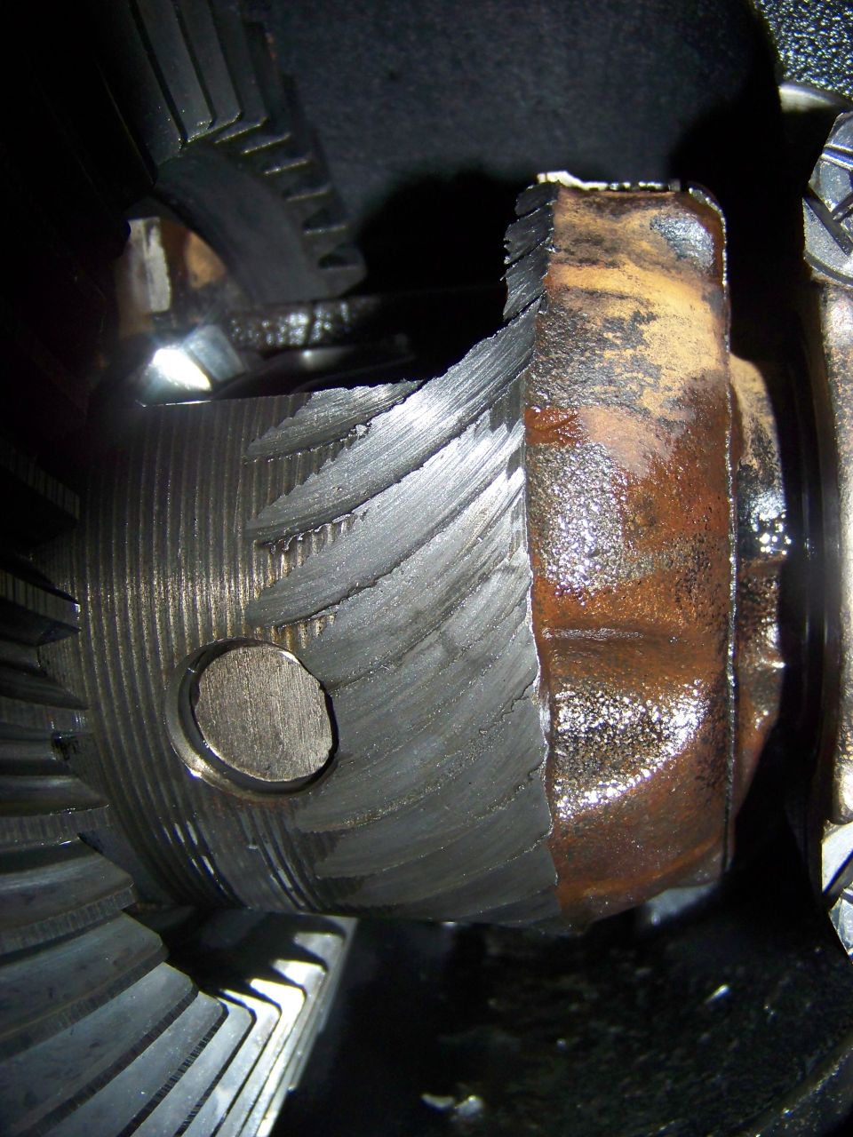 Damaged differential gear with broken teeth and rust.