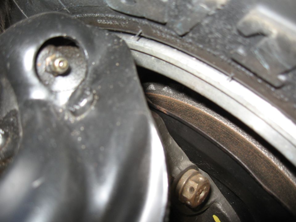 Close-up of a car's brake rotor, caliper, and tire.