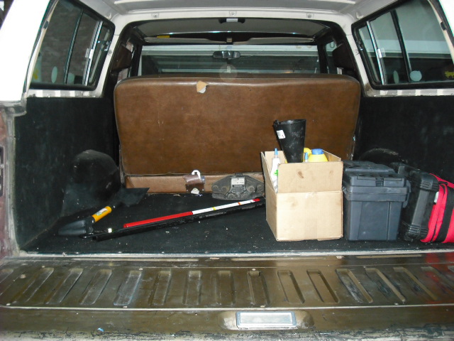 Interior rear cargo area of a vehicle with supplies.