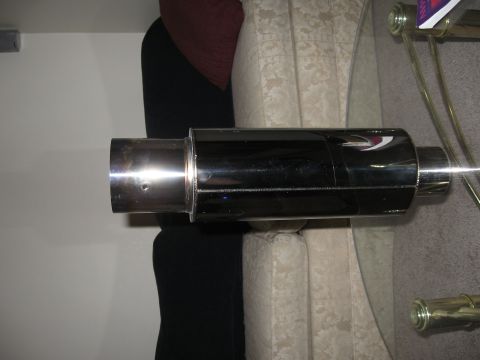 1991 Mitsubishi 3000GT - A close-up view of a black exhaust muffler with a chrome tip and a distinctive logo.