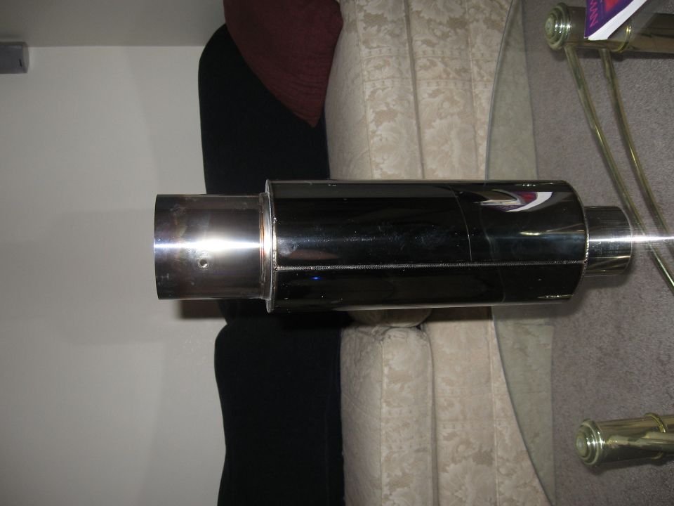 Black exhaust muffler with chrome tip and a red and white logo