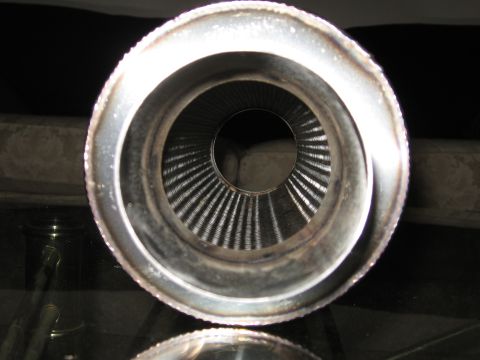 1991 Mitsubishi 3000GT - Close-up view of the inside of a metal exhaust pipe, showing internal baffles and a rough weld seam.