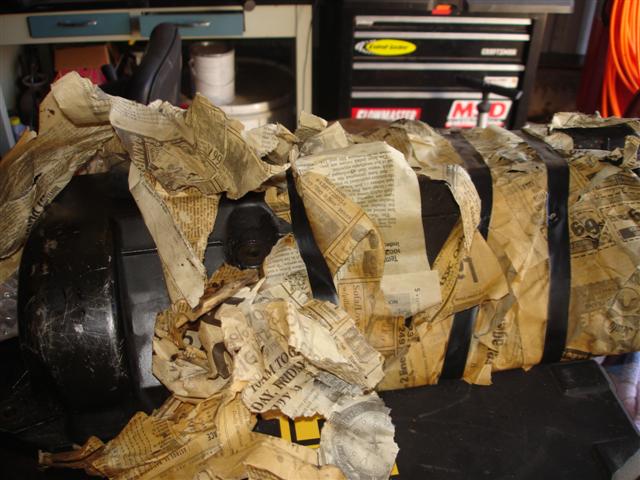 Object wrapped in newspaper and tape.