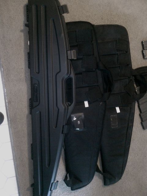 1990 Ford Bronco - Several black rifle cases and magazines are laid out on a carpeted floor.