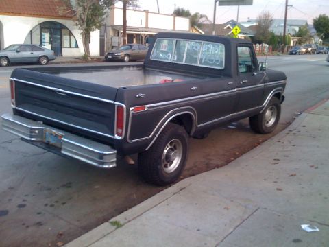 1979 Ford Bronco - This pickup truck, likely from the late 1970s, is parked curbside on a street with buildings in the background.