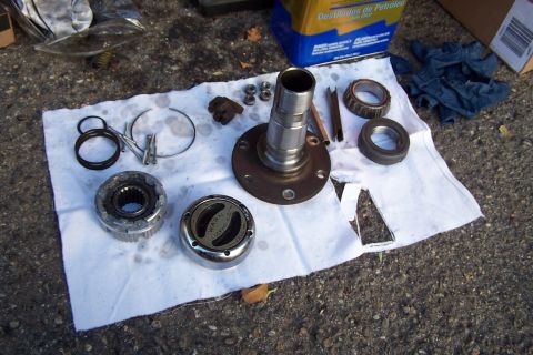 1990 Ford Bronco - Automotive parts, possibly for a 1990 Ford Bronco, are laid out for inspection or repair.