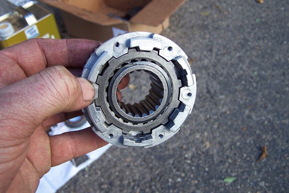 Hand holding a metal locking hub component with splines inside