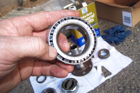 1990 Ford Bronco - A Timken wheel bearing is shown, with other automotive parts scattered on a white cloth.