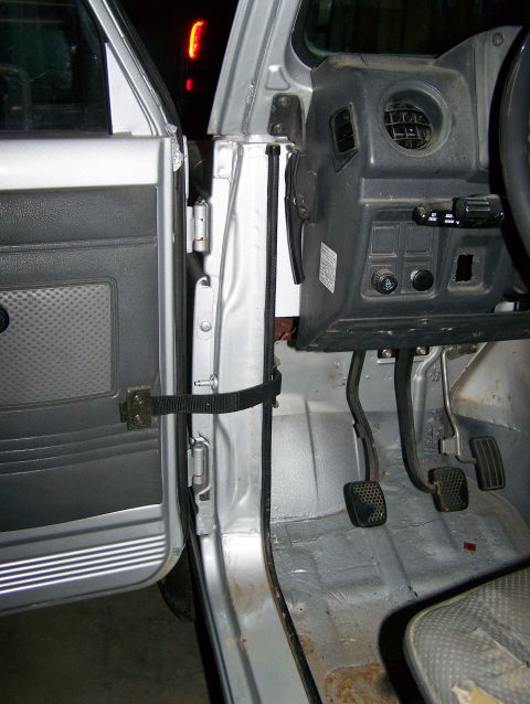 1988 Suzuki Samurai - Interior view of a Suzuki Samurai, highlighting the driver's side door, dashboard, and floor pedals.
