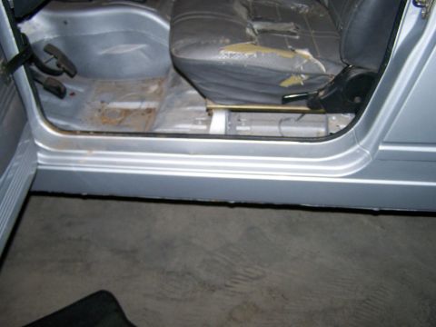 1988 Suzuki Samurai - Interior view of a vehicle's driver side, revealing a worn seat and exposed floor panels.
