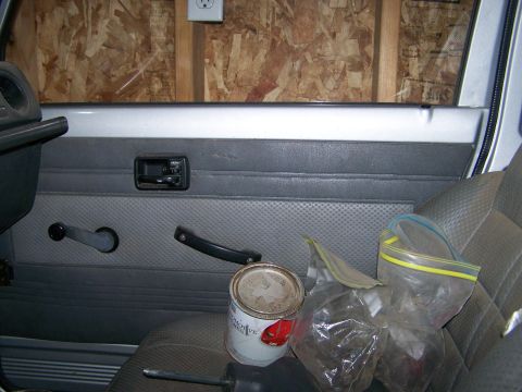 1988 Suzuki Samurai - Vehicle interior door panel detail, with a can of paint and plastic bags on the seat.