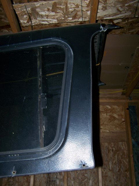 1988 Suzuki Samurai - Close-up of a Suzuki Samurai hardtop rear corner, showing the window frame and textured surface.