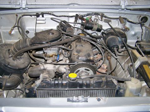 1988 Suzuki Samurai - Engine bay of a vehicle, showing the engine, radiator, and various hoses and wires.