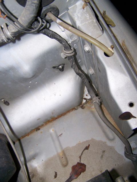 1988 Suzuki Samurai - Detail of wiring and metalwork in a vehicle's engine compartment, showing signs of age and rust.