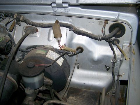1988 Suzuki Samurai - Close-up of engine bay components, including wiring and brake booster, with some legible text on a label.