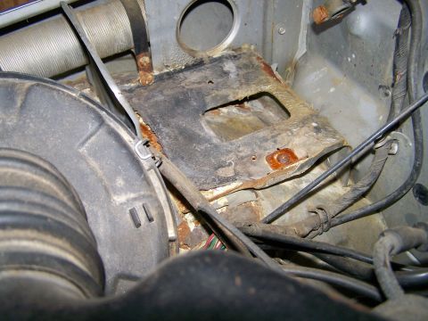 1988 Suzuki Samurai - Close-up view of a rusted engine bay component with visible wiring and hoses.