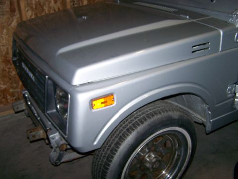 1988 Suzuki Samurai - A silver 1988 Suzuki Samurai is shown from the front three-quarter view.