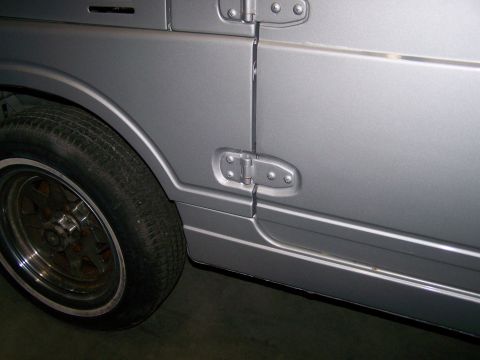 1988 Suzuki Samurai - Close-up of a silver SUV's side panel, showing the door seam, fender, and wheel.