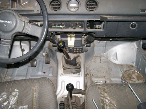 1988 Suzuki Samurai - Interior view of a Suzuki Samurai, showing the dashboard, steering wheel, and manual transmission gear selectors.