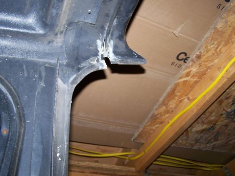 1988 Suzuki Samurai - Close-up view of a vehicle's interior wheel well, showing construction details and surrounding unfinished attic space.