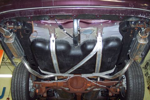 2001 Ford Crown Victoria - The underside of a vehicle is viewed from below, revealing its exhaust system and fuel tank.